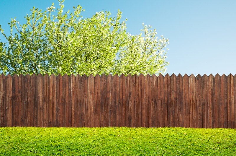 a wooden garden fence at backyard and bloom tree in spring a wooden garden fence Sustainable pest control company in Norfolk
